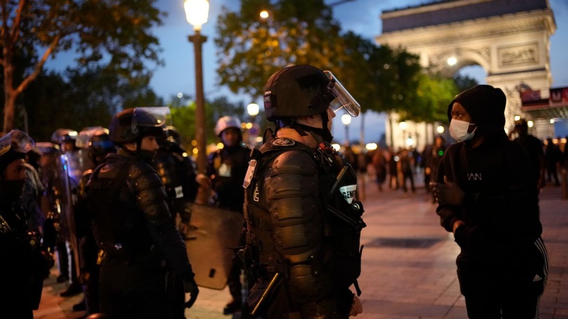 En polis pratar med en tonåring framför Champs Elysees i Paris på lördagskvällen. Foto: Christophe Ena