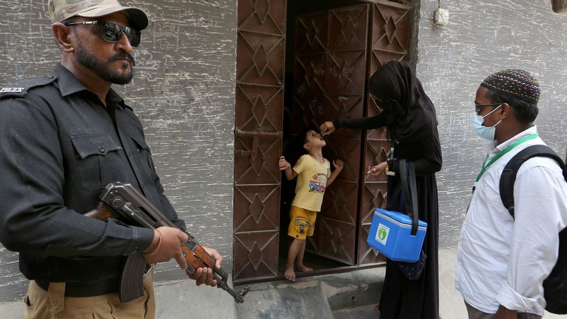 Talibaner i Pakistan angriper med jämna mellanrum den vaccininsats som pågår för att stävja polio i landet. Här står en polis vakt medan ett barn vaccineras i Karachi. Arkivbild. Foto: Fareed Khan/AP/TT