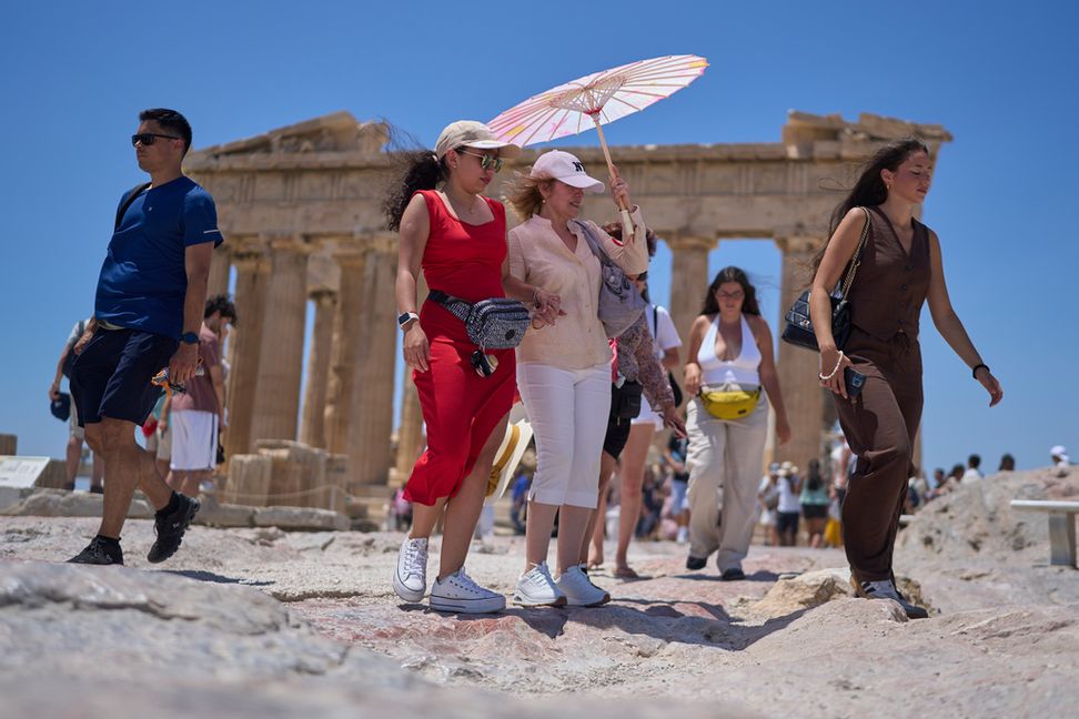 Turister i värmen vid Akropolis i Aten i slutet av juni. Foto: Petros Giannakouris/AP/TT