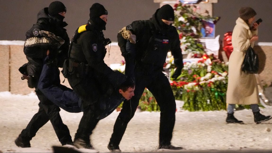 Polis för bort en man som lagt blommor vid en minnesplats för Aleksej Navalnyj i S:t Petersburg. Foto: AP/TT