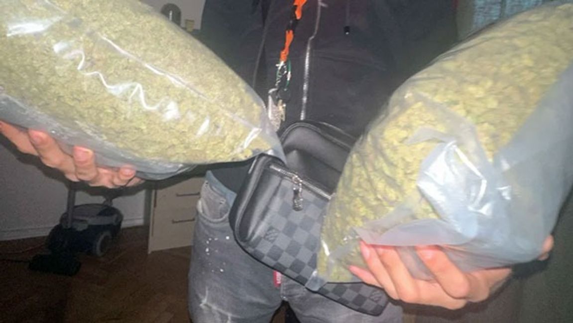 En av de åtalade männen poserar med cannabis-påsar. Bild: FUP