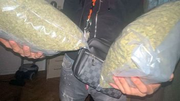 En av de åtalade männen poserar med cannabis-påsar. Bild: FUP