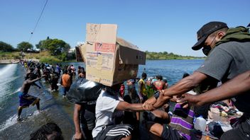 Haitian migrants use a dam to cross to and from the United States from Mexico, Friday, Sept. 17, 2021, in Del Rio, Texas. Thousands of Haitian migrants have assembled under and around a bridge in Del Rio presenting the Biden administration with a fresh and immediate challenge as it tries to manage large numbers of asylum-seekers who have been reaching U.S. soil. Photo: Eric Gay/AP/TT