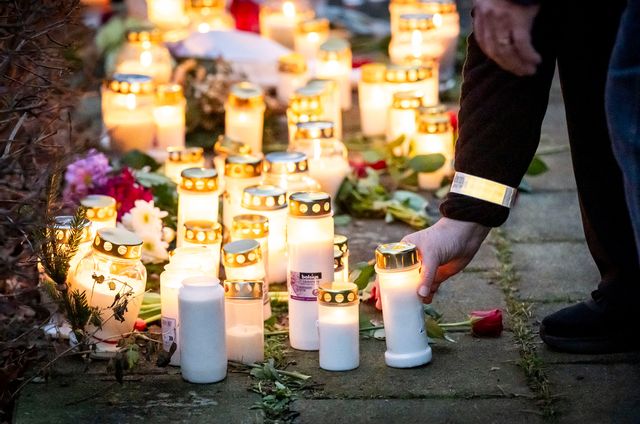 Fler personer har lämnat blommor och tänt ljus vid minnesplatsen utanför bostaden där en kvinna och ett barn hittades döda i tisdags. Foto: Johan Nilsson / TT