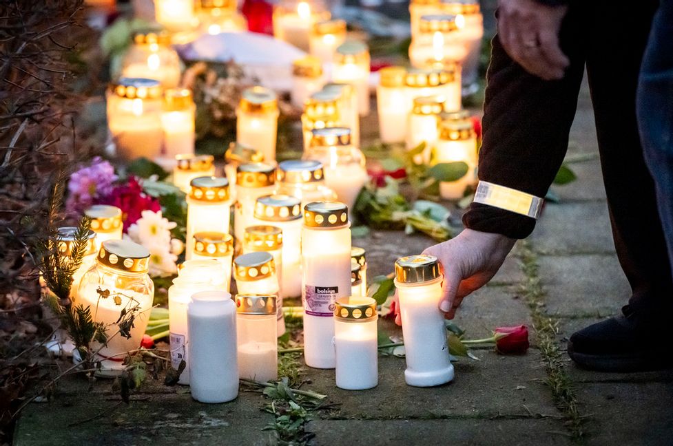 Fler personer har lämnat blommor och tänt ljus vid minnesplatsen utanför bostaden där en kvinna och ett barn hittades döda i tisdags. Foto: Johan Nilsson / TT