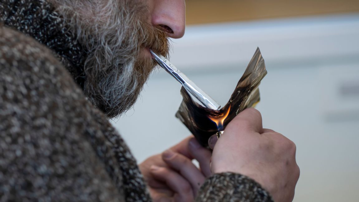 En man röker heroin i ett inhaleringsrum i Oslo. Foto: Heiko Junge/NTB scanpix/TT.