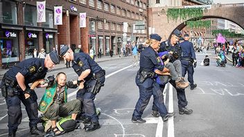 Polis lyfter bort klimataktivister från Extinction Rebellion efter en trafikblockad i Stockholm 2020. Foto Henrik Montgomery/TT