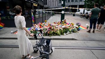 Människor har samlats och lägger blommor på platsen där två personer dödades och ett 20-tal skadades i ett islamistiskt terrordåd. Foto: Björn Larsson Rosvall/TT