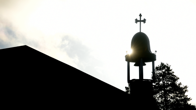 Silhuett av S:t Maria Syrisk ortodoxa kyrka i Tensta med klocktorn och kors. Foto: Janerik Henriksson / TT