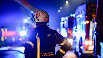 Brandman på plats och arbetar med en vindsbrand. Foto Johan Nilsson / TT