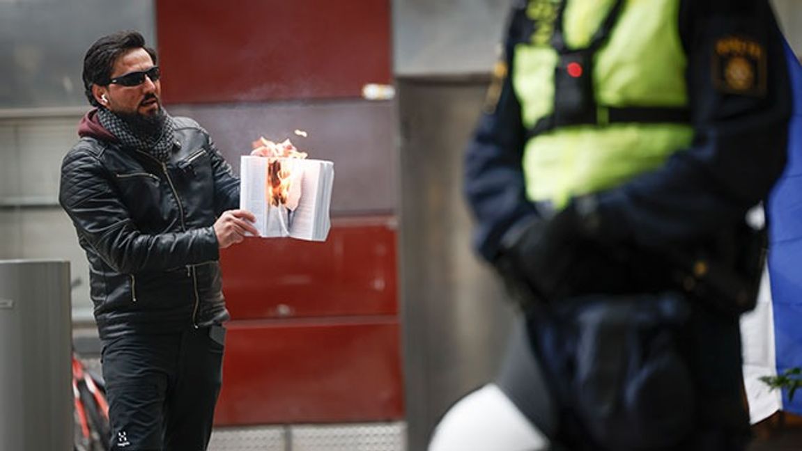 Salwan Momika eldar en bok under en allmän sammankomst vid Benny Fredriksssons torg i Stockholm i oktober 2023. Foto: Fredrik Persson / TT 