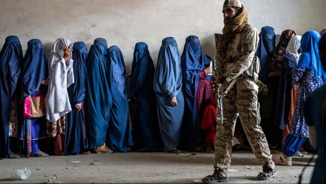 En taliban vaktar kvinnor som köar för hjälpsändningar med mat i Kabul. Arkivbild. Foto: EBRAHIM NOROOZI/AP/TT