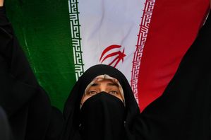 Iransk kvinna som håller upp sitt lands flagga under en regimvänlig demonstration i Teheran, tisdagen 24 juni, medan regimkritiker löper ökad risk att fängslas. Foto: Vahid Salemi/AP/TT