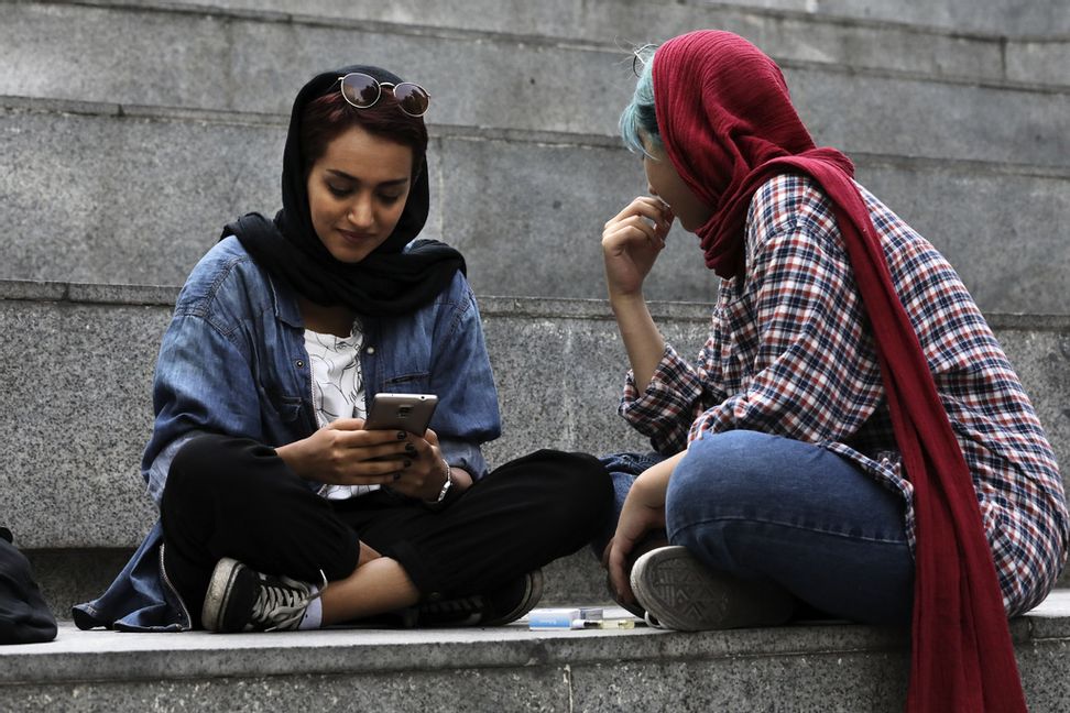 En ung kvinna kollar sin mobil i Teheran. Står kärleken att finna i flödet? Arkivbild. Foto: Vahid Salemi/AP/TT.