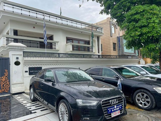Bilar med falska diplomatiska registreringsskyltar parkerade utanför det hyreshus i Ghaziabad utanför New Delhi där polis misstänker att en 47-årig man legat bakom ett avancerat bedrägeri med en falsk ambassad. Bild från måndag 21 juli. Polisen i Uttar Pradesh via AP/TT
