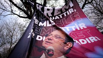 En man hänger upp en bild föreställande Istanbuls borgmästare Ekrem Imamoglu i ett träd, under en protest mot hans frihetsberövande. Bild tagen den 20 mars. Emrah Gurel/AP/TT