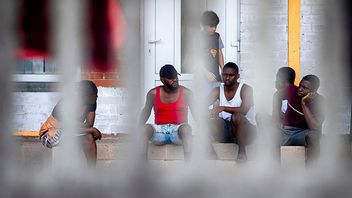 Migrants rest at the refugee camp in Druskininkai, some 145km (99,1 miles) south from Vilnius, Lithuania, Tuesday, July 13, 2021. Lithuania has struggled with a flow of migrants from the Middle East and Africa — a huge influx that officials in the tiny Baltic country say was organized by Belarusian authorities as part of a ”hybrid war” against the European Union. Photo: Mindaugas Kulbis/AP