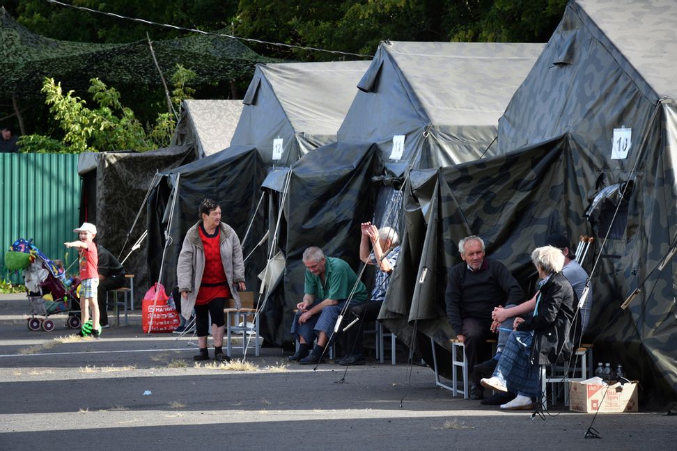 Evakuerade i regionen Kursk sitter vid tält på ett tillfälligt boendecenter. Bilden togs på måndagen. AP/TT