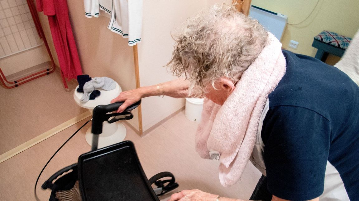 En äldre dam får hjälp med att tvätta håret av en vårdare. Foto: Gorm Kallestad / NTB scanpix / TT