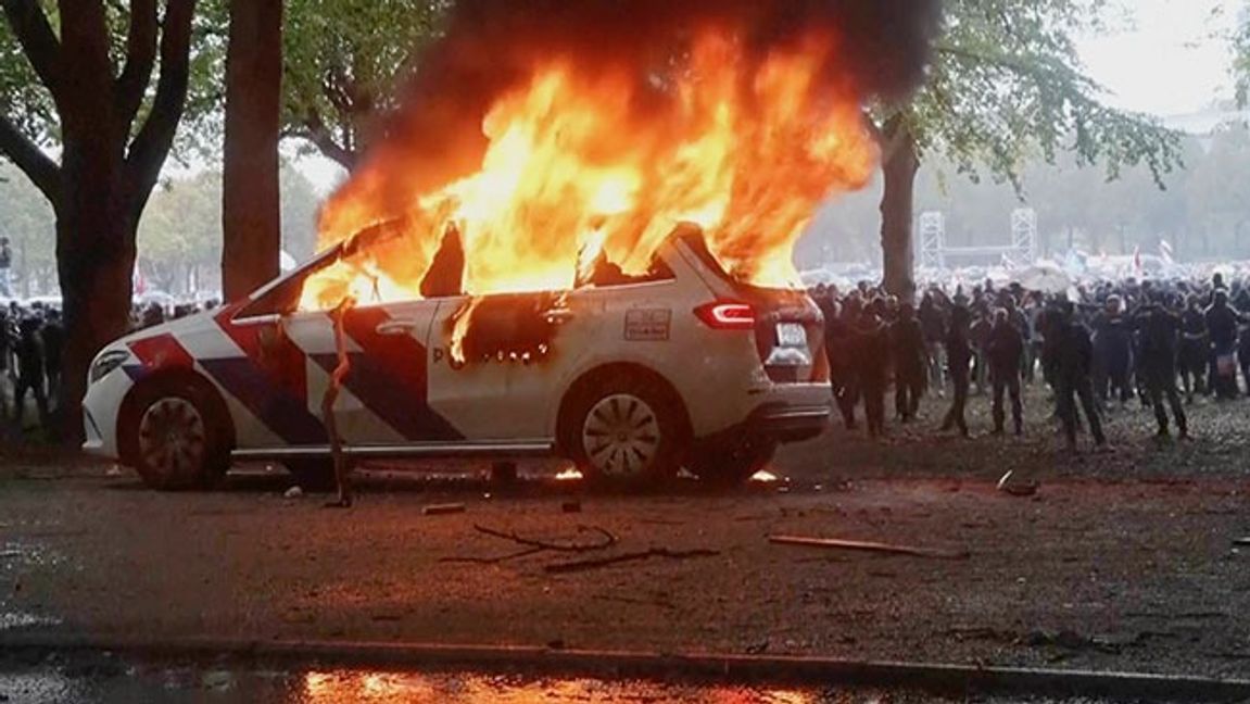 Polisbil i brand under lödragens upplopp i Haag. Bild: REGIO8 via A
