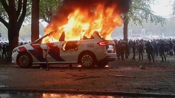 Polisbil i brand under lödragens upplopp i Haag. Bild: REGIO8 via A