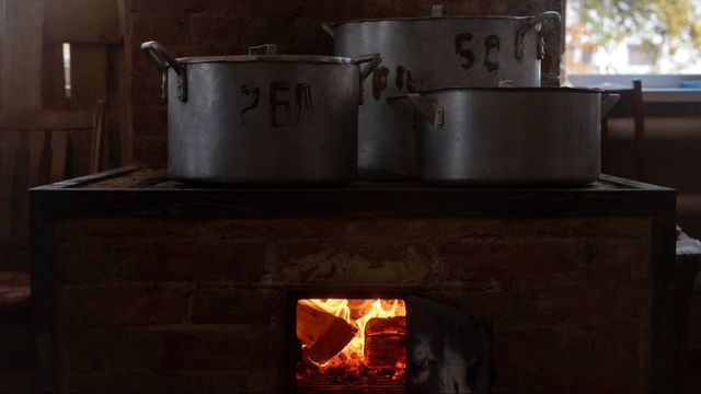 Mat lagas på en vedspis på Sjostkas sjukhus i nordöstra Ukraina under ett rullande strömavbrott den 16 oktober 2025 samtidigt som det inte fanns naturgas. Vedeldning och andra lösningar fungerar för att hålla värmen och kunna laga maten fungerar för en del, men inte för de miljontals ukrainare som bor i lägenheter utan sådan möjligheter. Foto: AP Photo/Julia Demaree Nikhinson