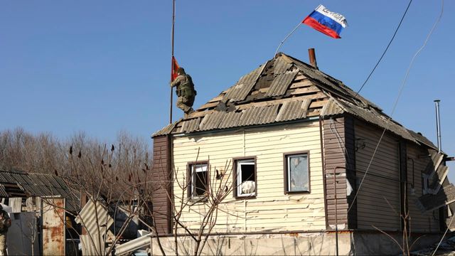 En rysk soldat reser en rysk flagga på ett hus i Kurskregionen den 14 mars efter att området i fråga tagits över av Ryssland. Foto: Ryska försvarsministeriets presstjänst via AP
