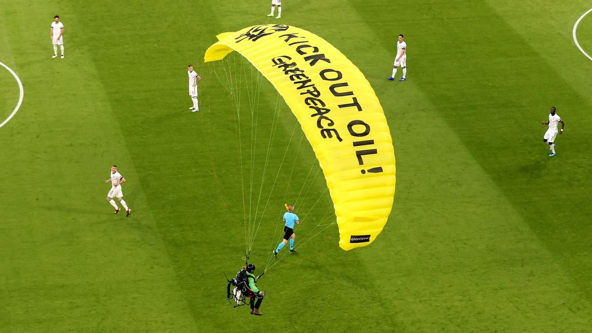 En aktivist från Greenpeace flyger in på arenan under fotbolls-EM i München. Foto: 	Alexander Hassenstein / TT