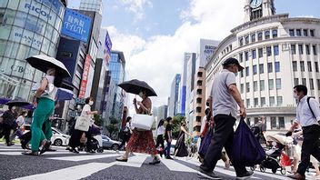 People wearing face masks to help protect against the spread of the coronavirus walk under the scorching sun in the Ginza Shopping district Tuesday, Aug. 10, 2021, in Tokyo. Photo: Eugene Hoshiko/AP