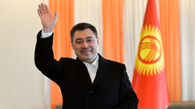 Sadyr Japarov vinkar till journalister när han lägger sin röst i det kirgiziska presidentvalet. Vladimir Voronin/AP/TT.