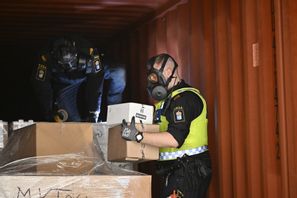Tullinspektörer öppnar en container för att kontrollerar innehållet i samband med att statsminister Ulf Kristersson och justitieminister Gunnar Strömmer besöker tullen i Norviks hamn i Nynäshamn i maj 2024. I hamnen gjordes ett rekordbeslag av kokain i april i fjol. Foto: Henrik Montgomery/TT