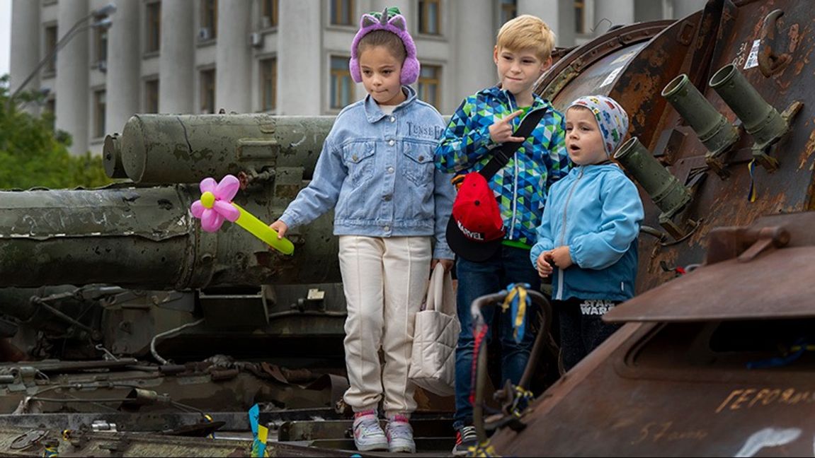 Ukrainska barn poserar på en utbränd rysk tank i Kiev i söndags. Foto: Frank Gunn/AP/TT