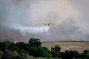 Ett brandbekämpningsflyg arbetar med att släcka en skogsbrand i närheten av Spaniens huvudstad Madrid på torsdagen. Foto: A. Pérez Meca/AP/TT