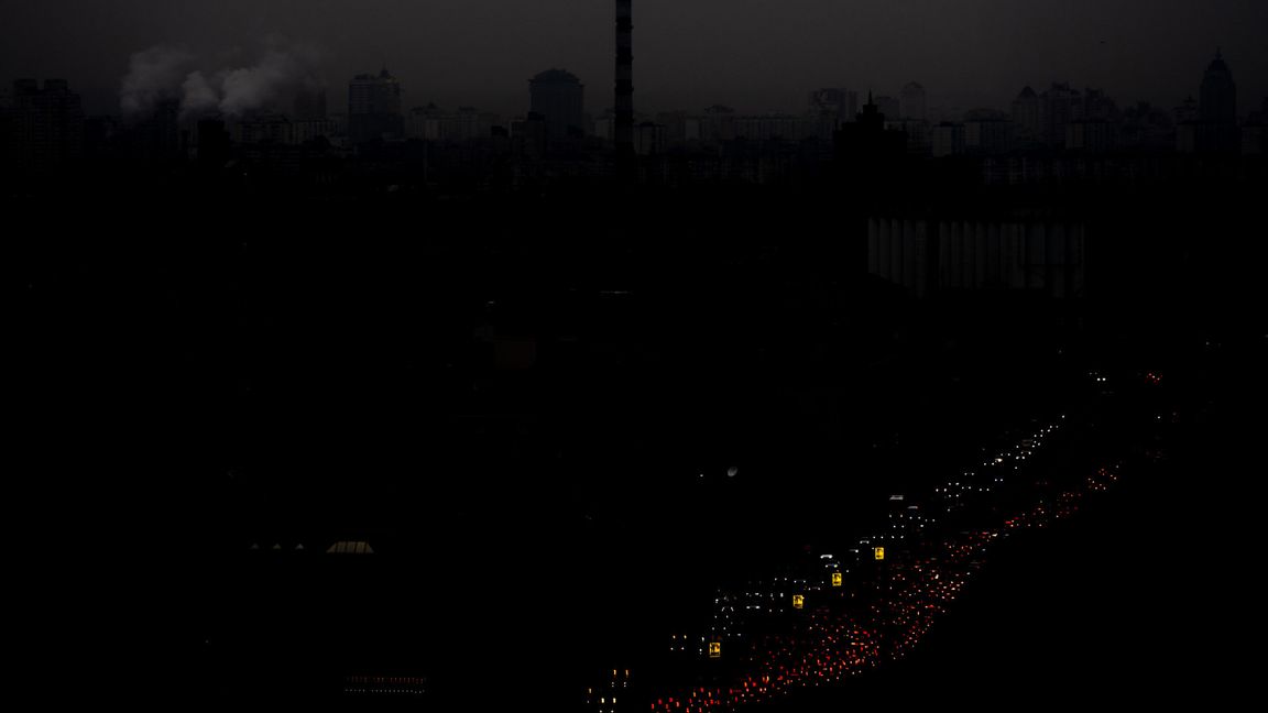 Bilar kör genom till en del av Kiev som har totalt strömavbrott i skymningen lördagen den 8 november 2025. Foto: AP Photo/Julia Demaree Nikhinson  