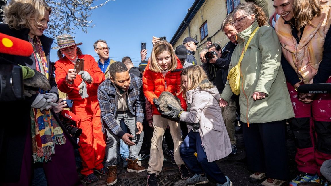 Emilia och Sally, boende i Christiania, tar hand om den första stenen som grävs upp från Pusher Street i Christiania i Köpenhamn på lördagen. Foto: Johan Nilsson/TT