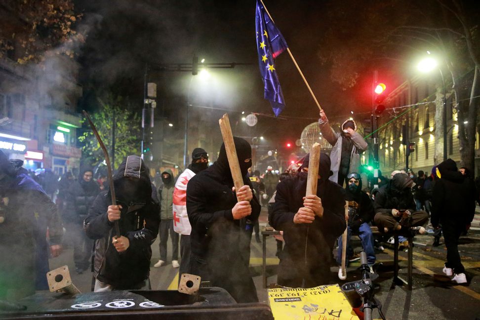 Demonstranter i Georgiens huvudstad Tbilisi försöker ta sig förbi en barrikad, under natten mot tisdagen. Foto: Zurab Tsertsvadze/AP/TT