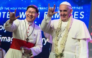 Favorittippade Luis Antonio Tagle gör tecknet ”jag älskar dig” med påve Franciskus i Filippinernas huvudstad Manila 2015. Foto: Osservatore Romano, Pool via AP/TT