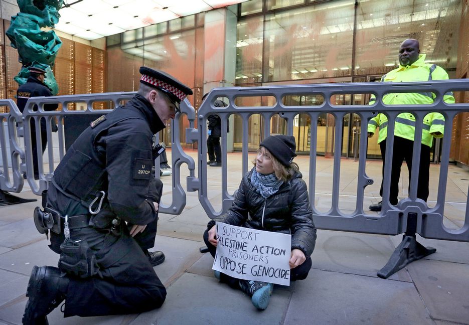 Greta Thunberg under demonstrationen där hon syns hålla upp ett plakat med texten ”Jag stödjer fångarna från Palestine Action. Jag är emot folkmord”. Prisoners for Palestine/AP/TT