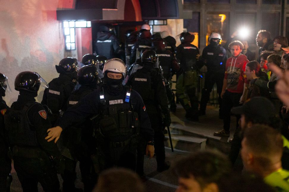 Serbisk polis tar sig igenom en folkhop som blockerar ingången till den statliga tv-stationen RTS lokaler i centrala Belgrad på måndagskvällen. Marko Drobnjakovic/AP/TT