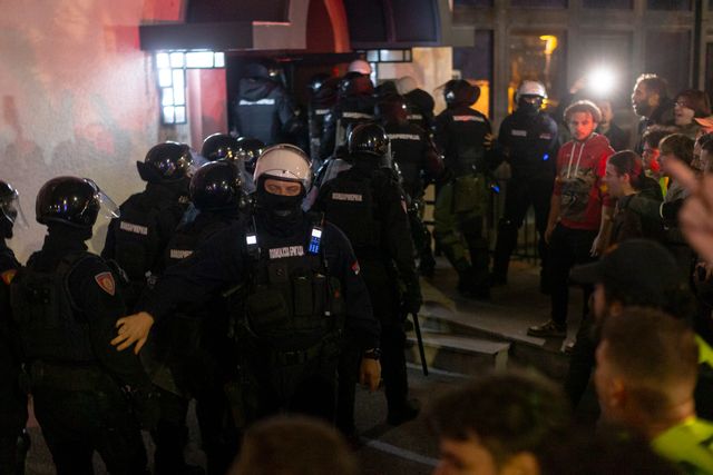Serbisk polis tar sig igenom en folkhop som blockerar ingången till den statliga tv-stationen RTS lokaler i centrala Belgrad på måndagskvällen. Marko Drobnjakovic/AP/TT