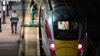 Ambulanspersonal arbetar vid LNER-tåget på Huntingdon station efter knivattacken som skadade tio personer. Foto: Chris Radburn/AP/TT.