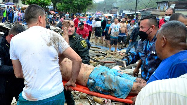 Räddningsarbetare och polis hjälper en person som låg under rasmassorna. Foto: Andres Otalvaro/AP/TT