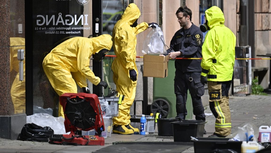 Tekniker från Nationella bombskyddet kommer ut med ett brev i en plastpåse vid Länsstyrelsen Skåne i centrala Malmö efter fynd av ett pulverlarm. Foto: Johan Nilsson/TT