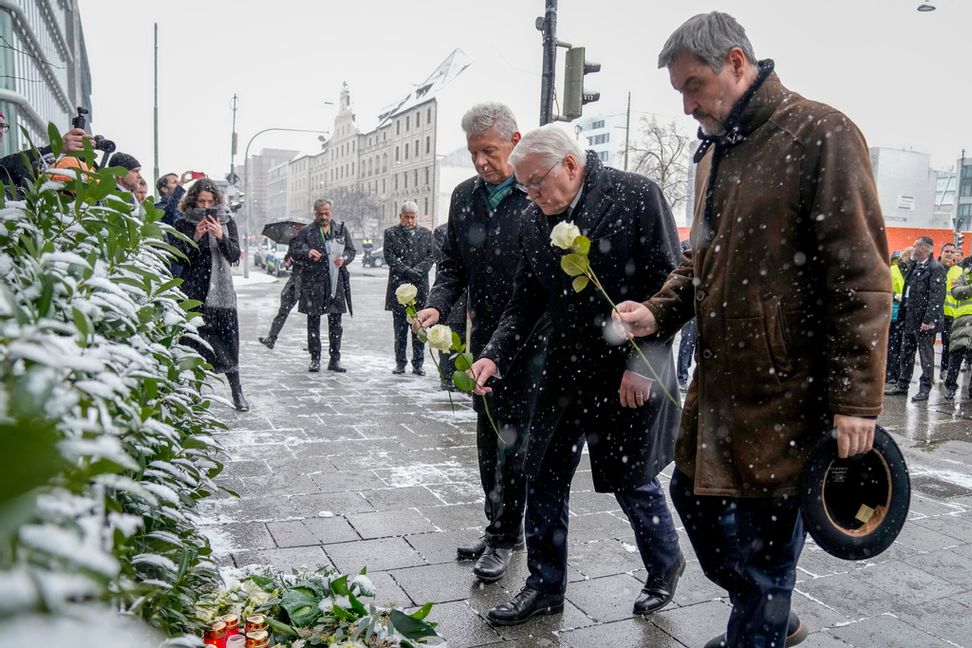 Bayerns ledare Markus Söder, Tysklands president Frank-Walter Steinmeier och Münchens borgmästare Dieter Reiter lämnar blommor vid platsen där över 30 personer skadades i ett dåd på torsdagen. Foto: Ebrahim Noroozi/AP/TT