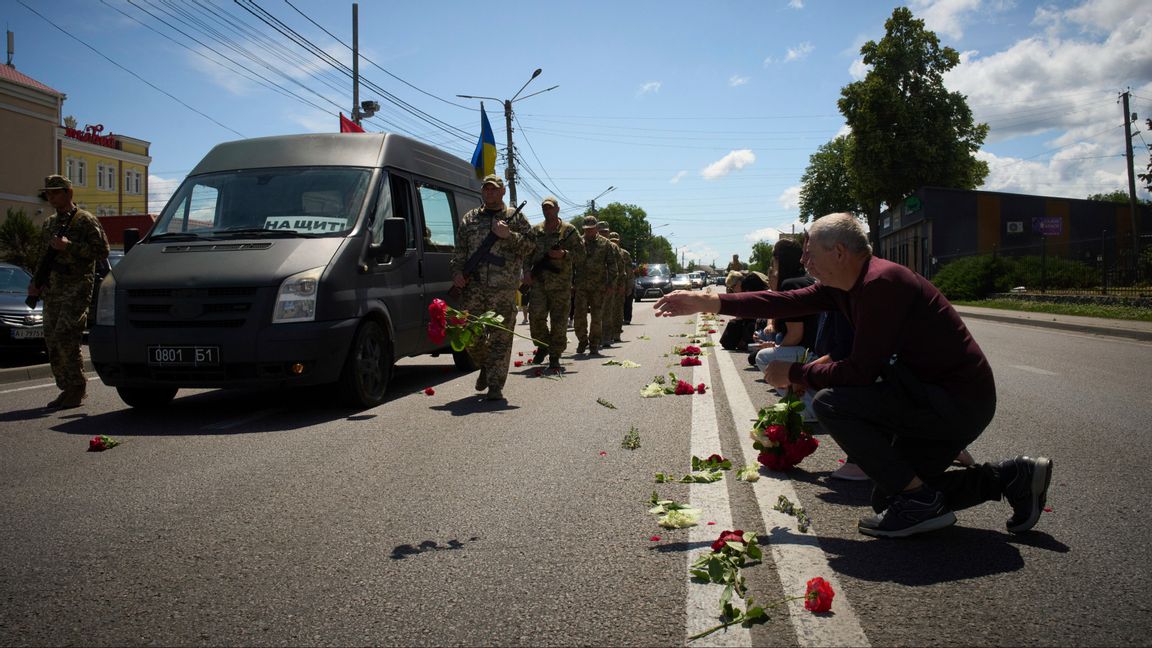 Bybor i Novi Petrivtsi utanför Ukrainas huvudstad Kiev kastar den 23 juni 2025 blommor på processionsvägen för begravningskortegen för Maksym Bulajev, en ukrainsk soldat som stupat i kriget mot Ryssland. Foto: AP Photo/Efrem Lukatsky