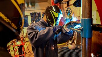  En lärare på industritekniska programmet på yrkesgymnasiet i Huddinge visar hur man sammanfogar plåtar i ett t-förband Foto: Jonas Ekströmer / TT 