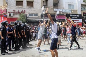 Demonstranter drabbar samman med polis i Tunisiens huvudstad Tunis under söndagen. Våldsamma demonstrationer har brutit ut på flera håll i landet i protest mot landets styre. Hassene Dridi/AP/TT
