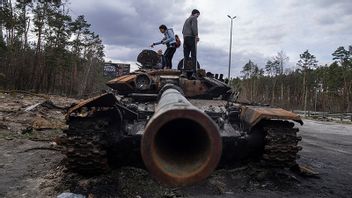 Lokalbor inspekterar en utslagen rysk tank i utkanten av Kiev. Foto: Evgeniy Maloletka/AP/TT