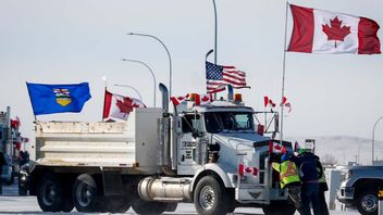 Försök att flytta en av lastbilarna som blockerar vägen vid Coutts i Alberta. Foto: Jeff McIntosh/AP/TT
