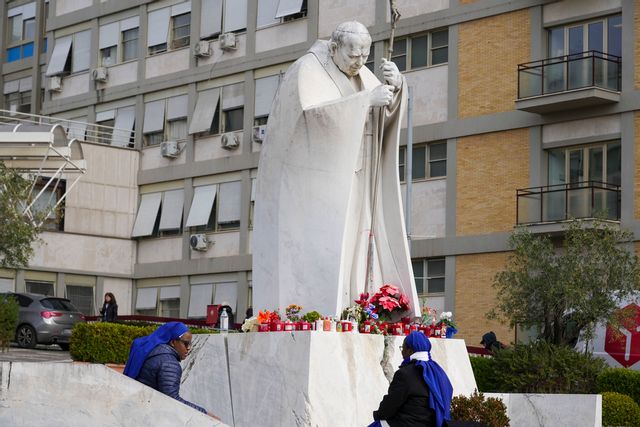 Nunnor lägger blommor vid en staty av påve Johannes Paulus II framför Gemelli-kliniken i Rom. Foto: Andrew Medichini/AP/TT